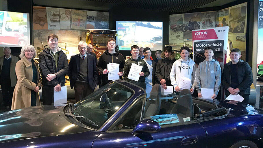 Image Photo – The youngsters with the car they renovated during the 10-week Mechanix course, Alison Jones, Community Affairs Manager at ExxonMobil Fawley, and Lord Montagu.